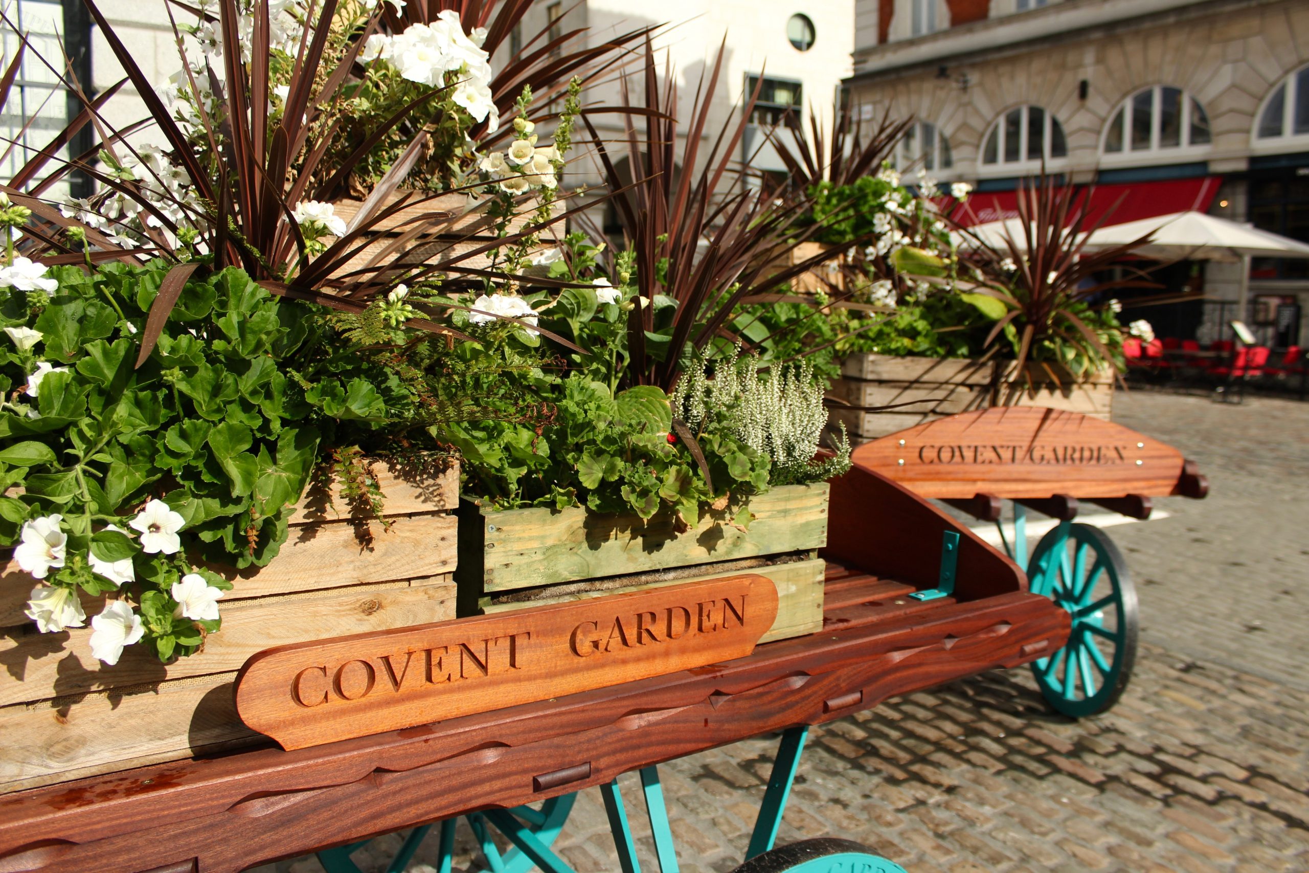 Rustic Flower Carts in Covent Garden Market Square, London, Adorned with Lush Greenery and Floral Arrangements Rustic Flower Carts in Covent Garden Market Square, London, Adorned with Lush Greenery and Floral Arrangements
