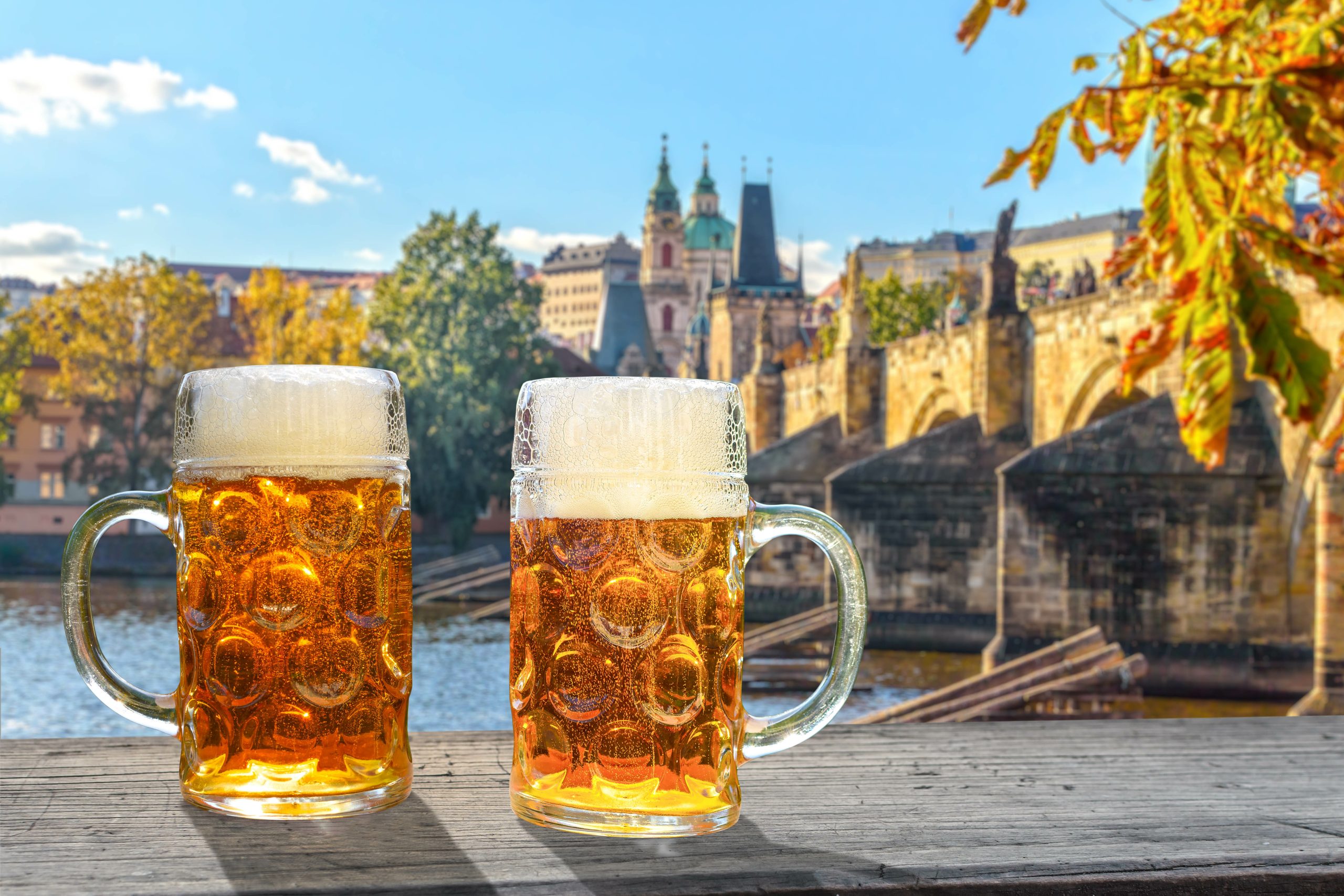 2 glasses of beer in the sunlight, in the background the view of Prague 2 glasses of beer in the sunlight, in the background the view of Prague