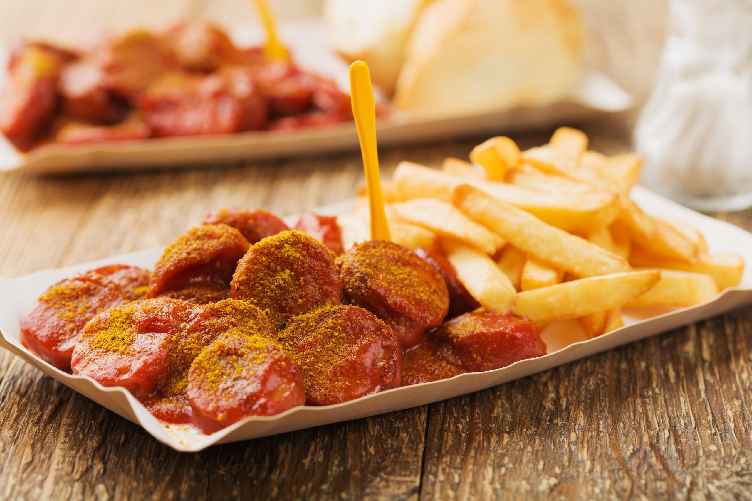 Traditional German currywurst, served with chips on disposable p