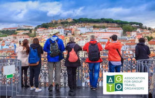 Group of people looking out to a bunch of buildings with the AGTO logo on the bottom right.