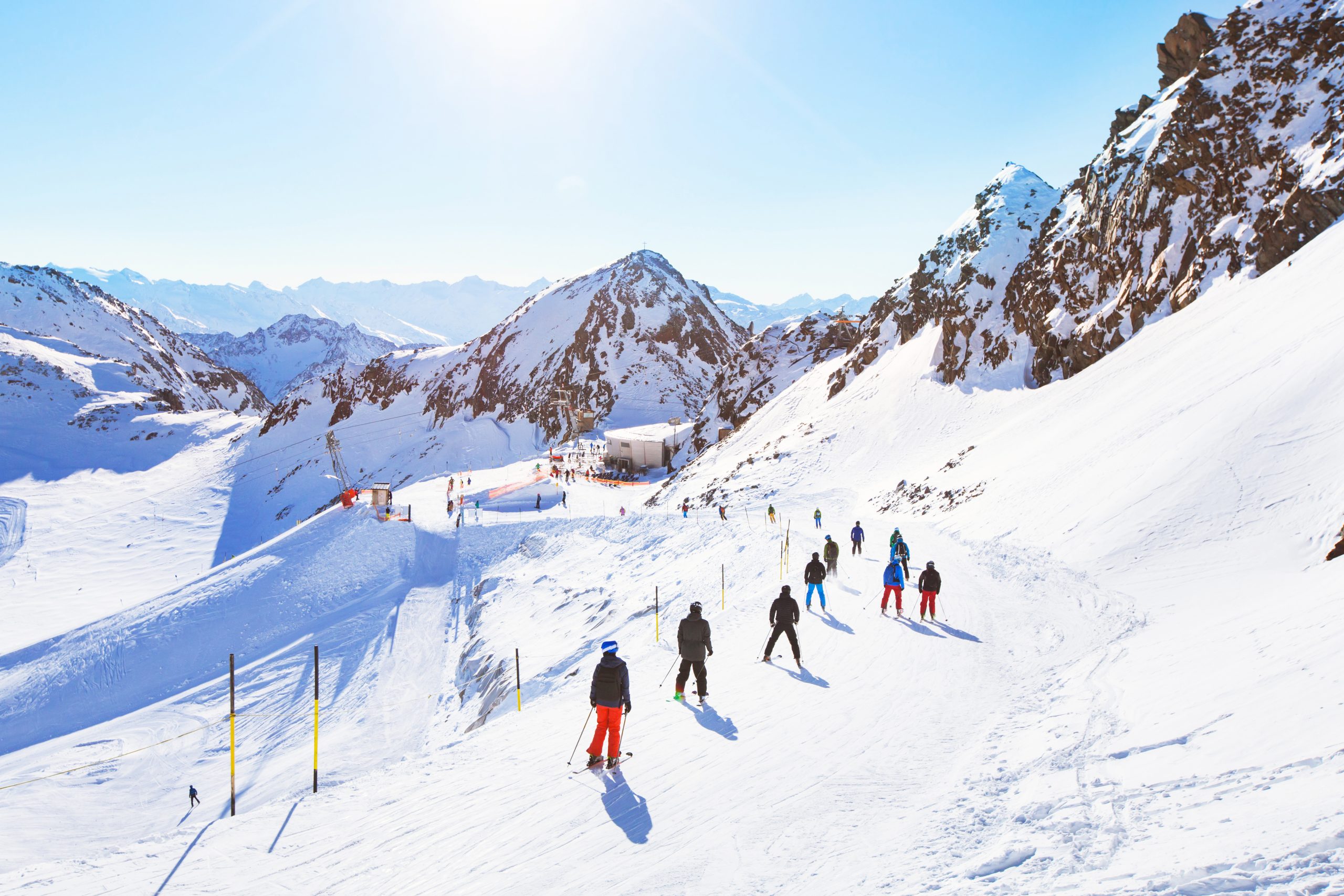 skiers on beautiful ski slope in Alps, people on winter holidays