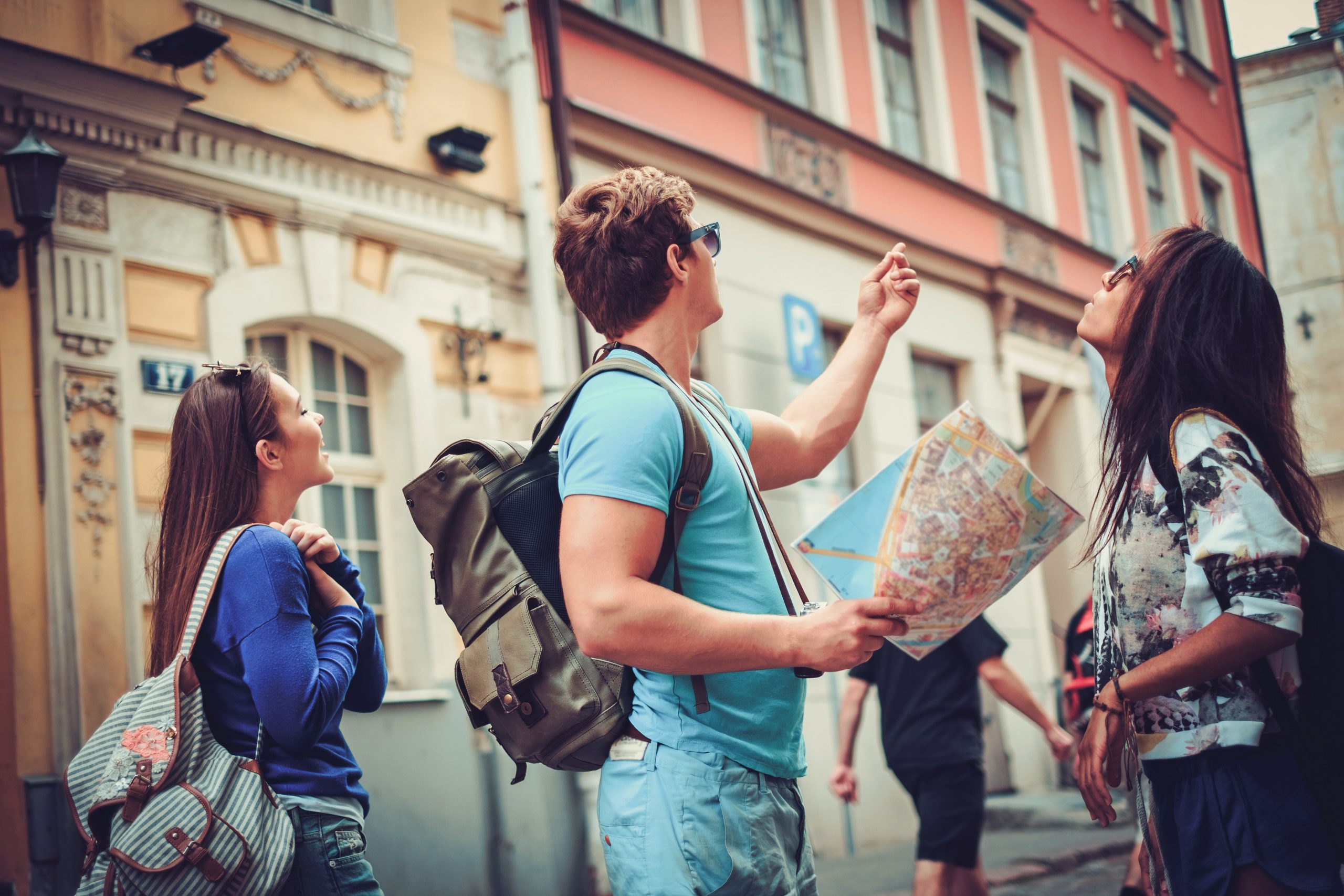 Multi ethnic friends tourists with map in old city