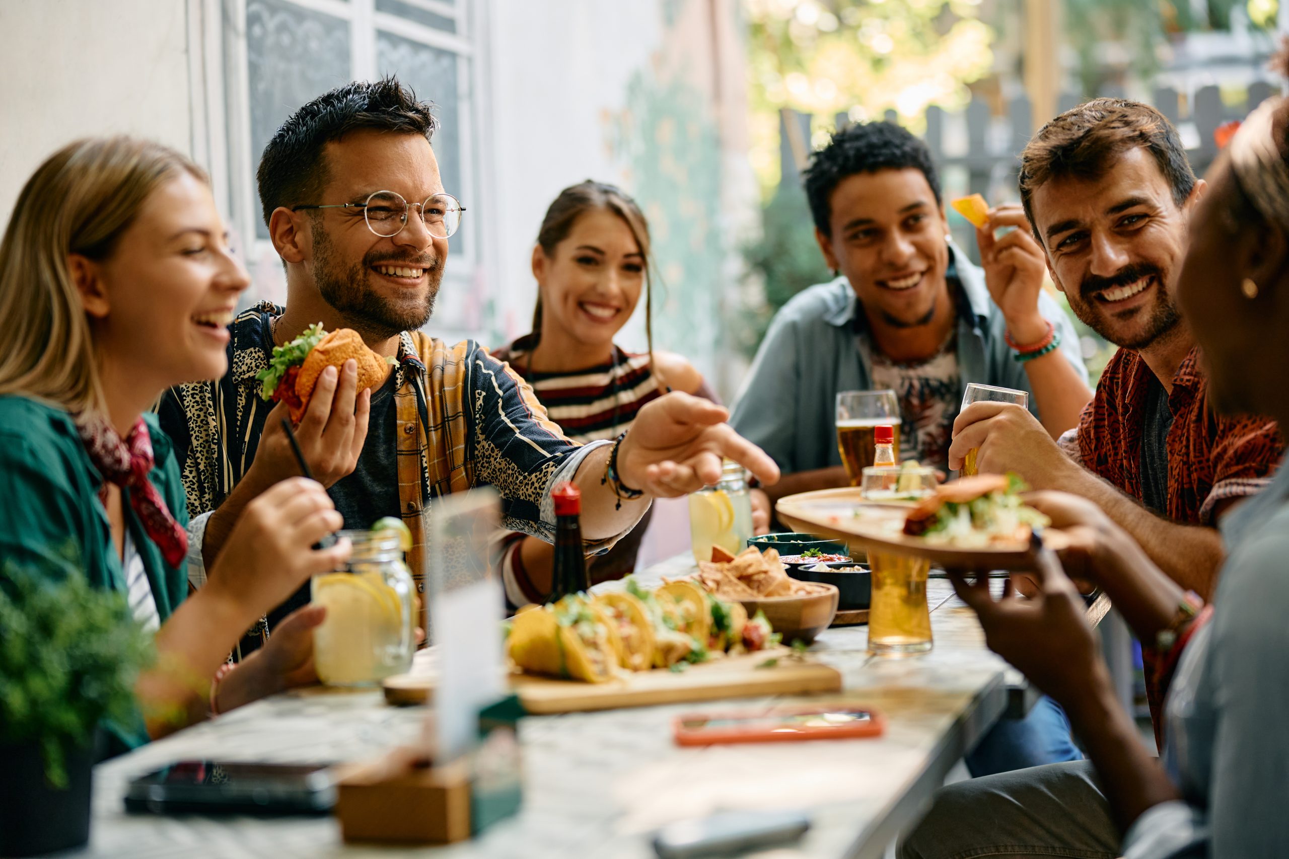 Cheerful friends enjoying in Mexican food in restaurant.