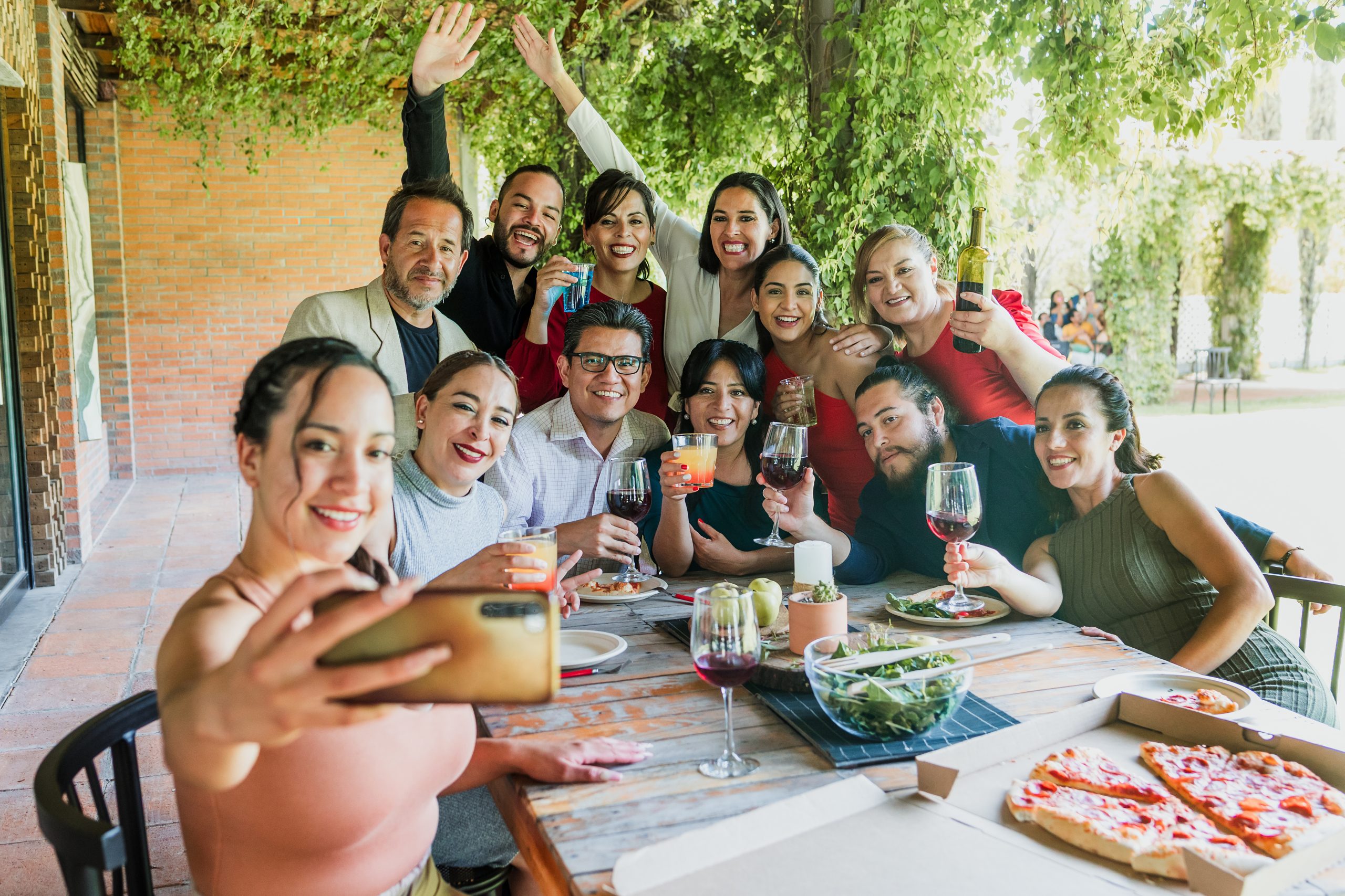 photo selfie with mobile phone of large group of friends or multi generation family eating and having a dinner in a terrace party in Mexico Latin America, portrait of hispanic people