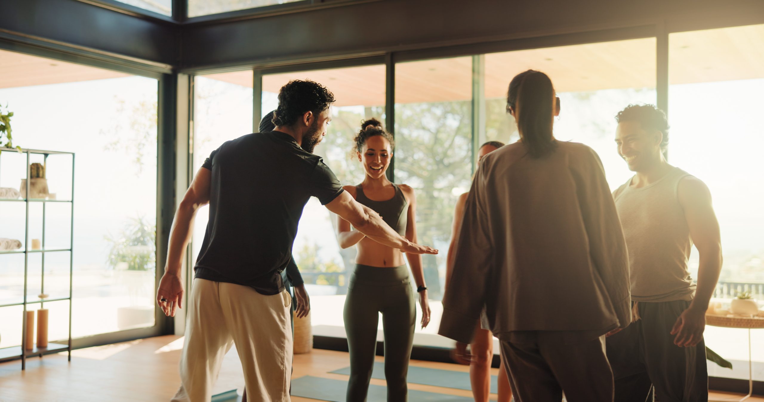 People, instructor and hand stack in yoga class with support, motivation and fitness success. Smile, men and women huddle for teamwork, wellness collaboration and agreement with self care achievement